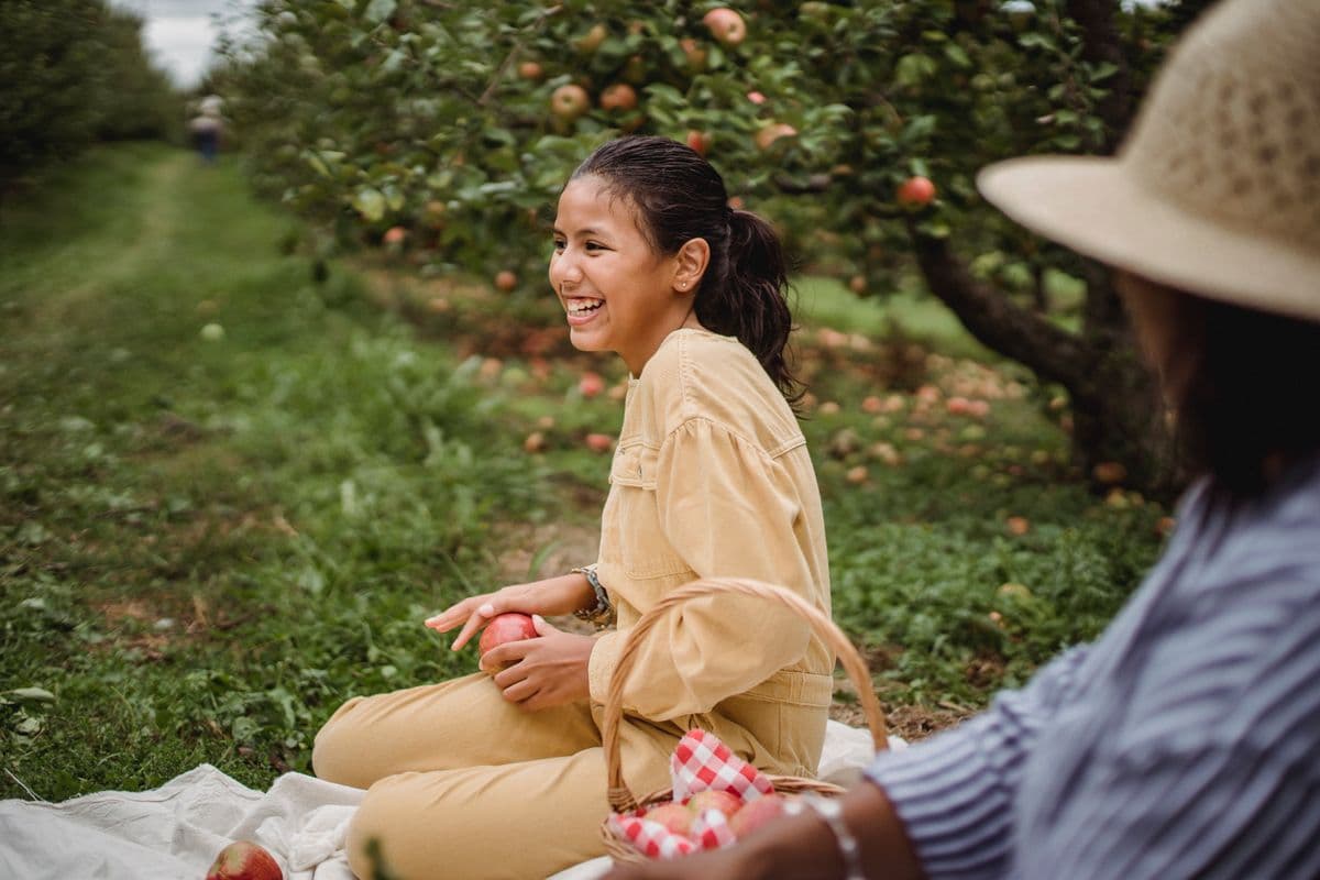 Teenager laughing in a sunlit orchard